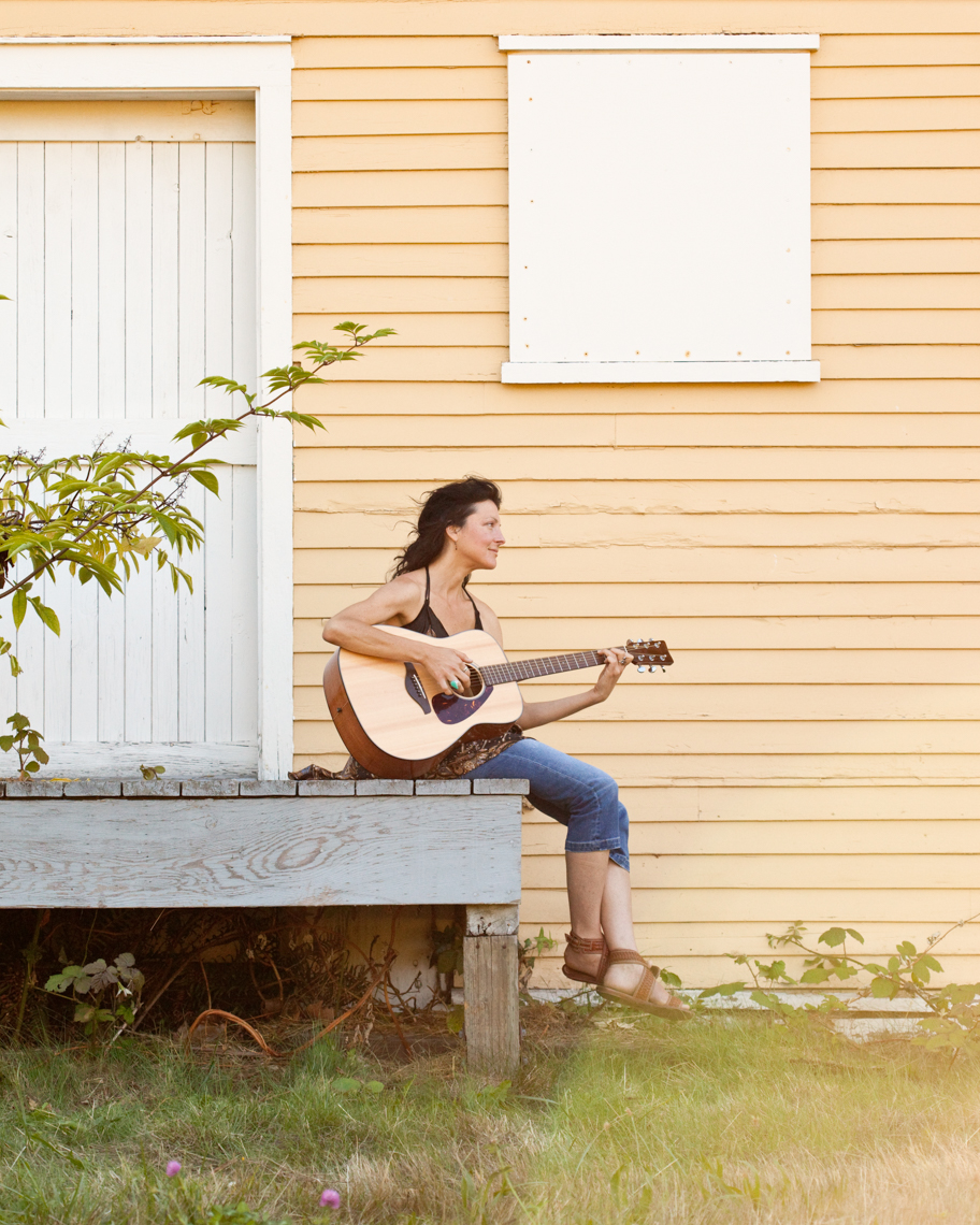Beautiful, happy, healthy, creative young woman playing guitar outdoors. Women