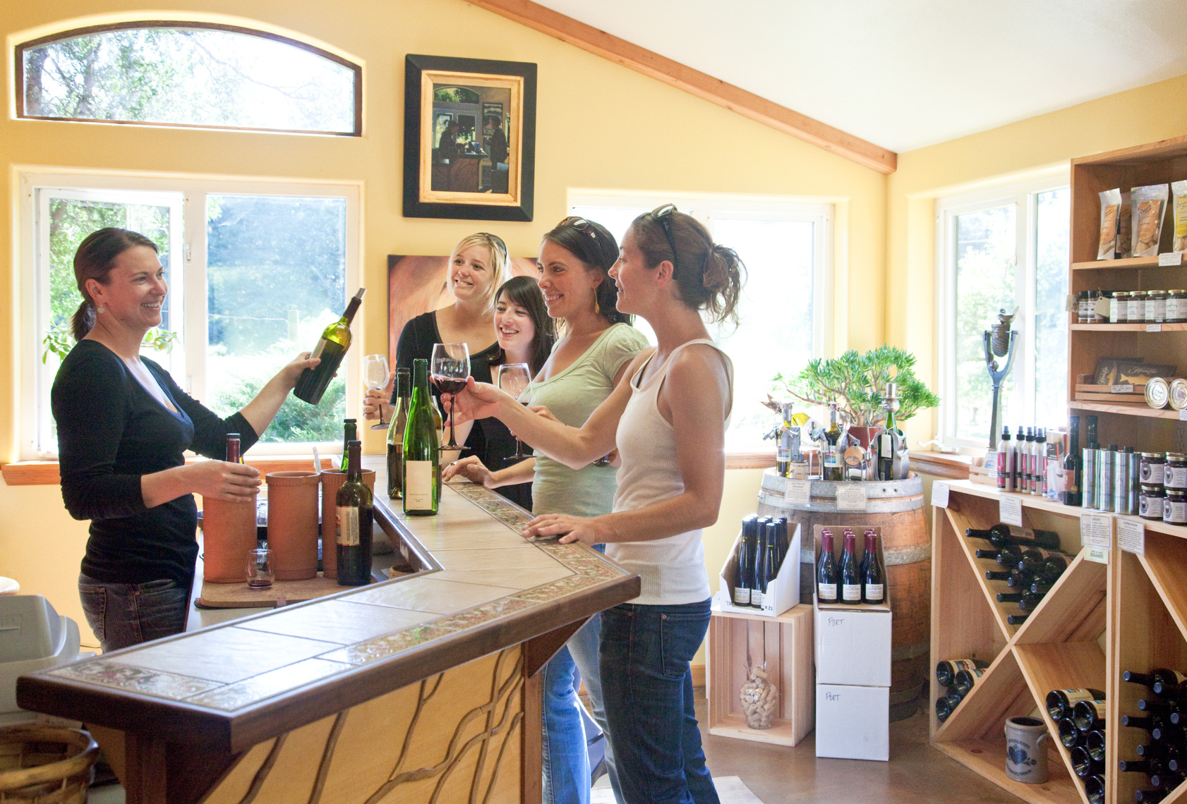 Women friends having fun wine tasting in winery tasting room