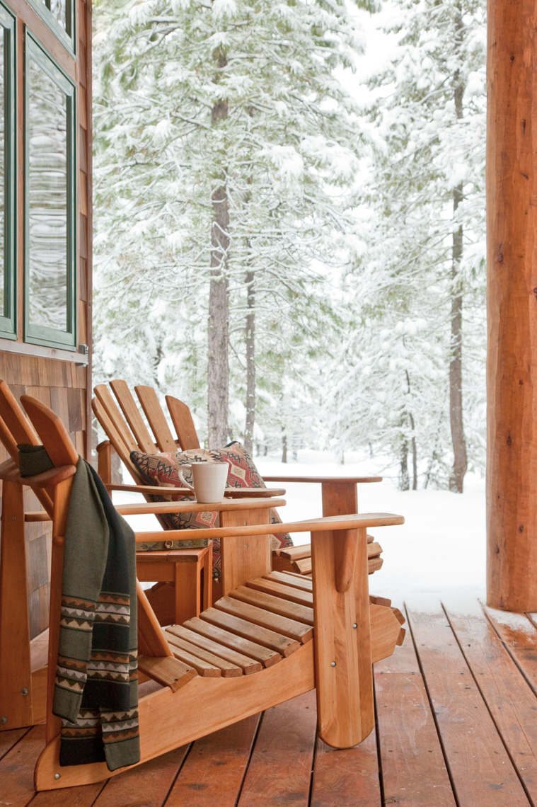 Adirondack chairs on deck with snowy landscape in background