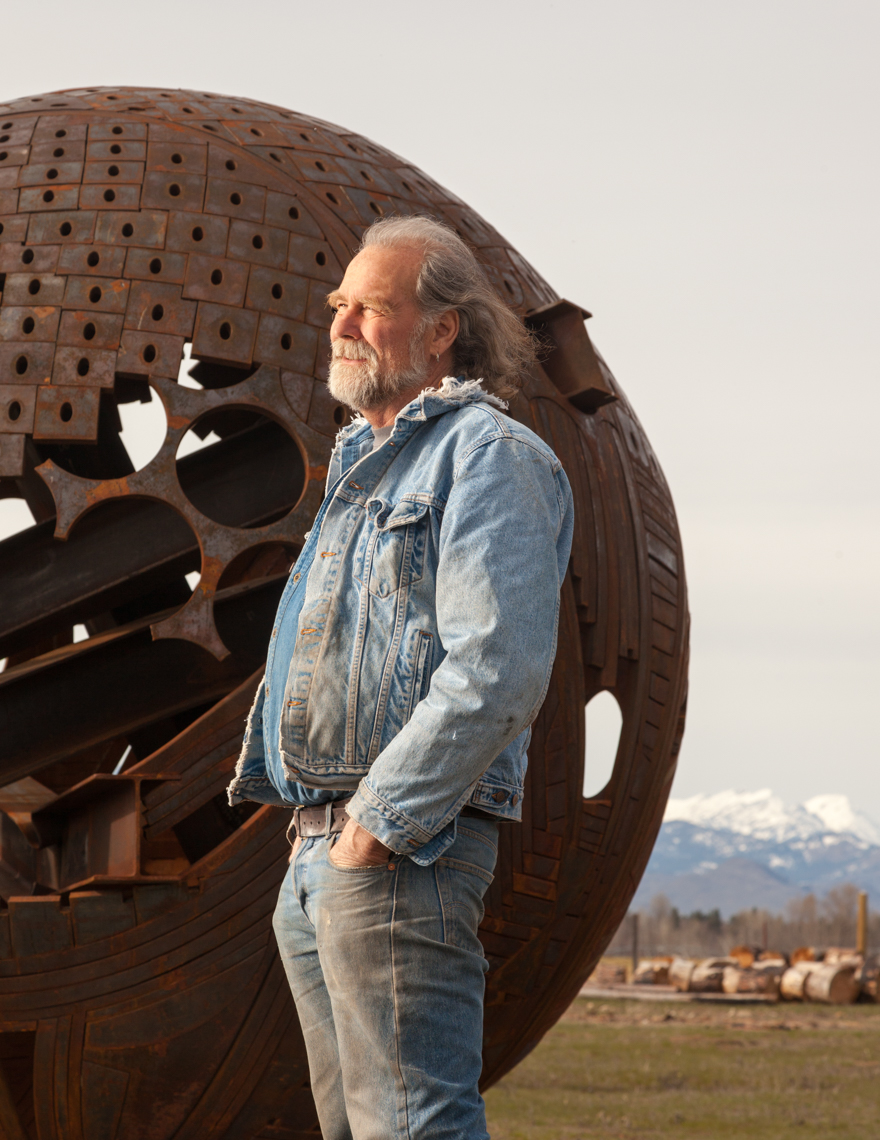 Mature senior man artist with modern, abstract art steel sculpture. Creative, unique people. 
