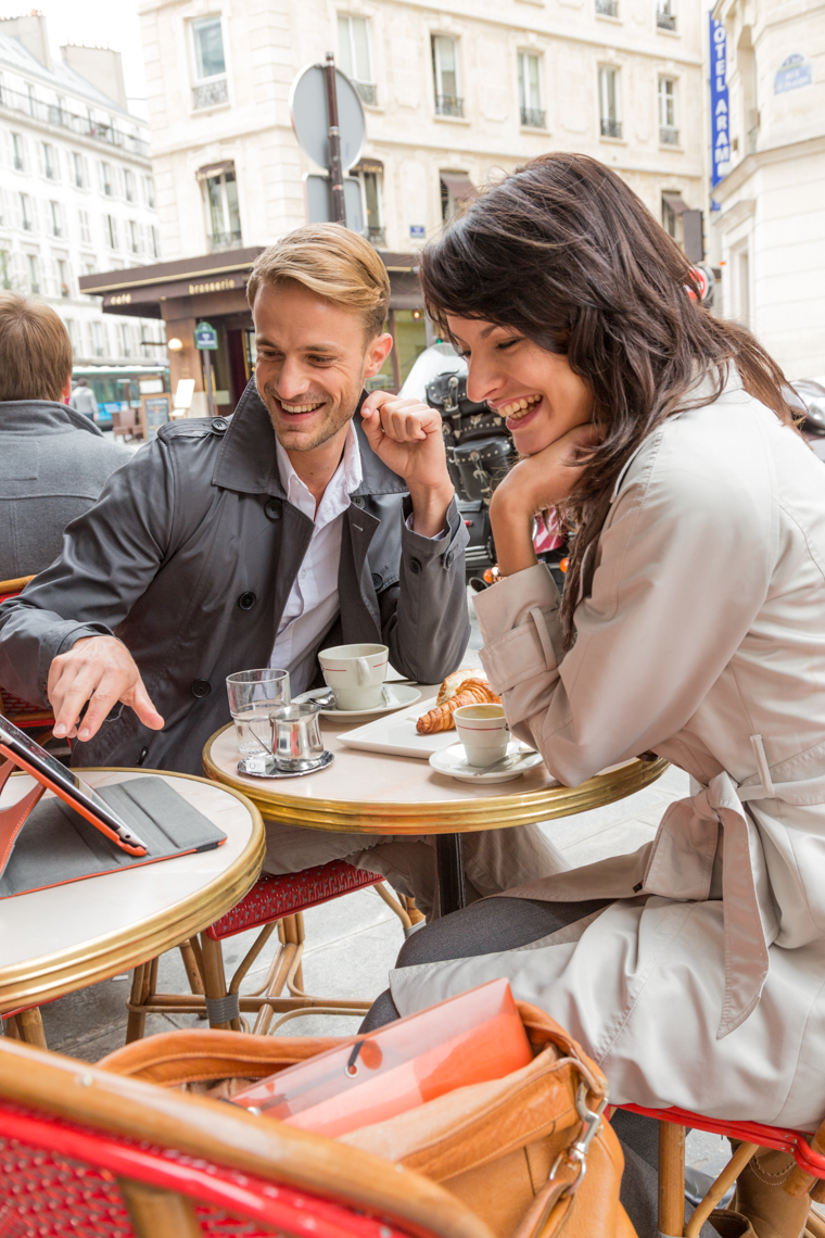 Couple at cafe looking at tablet computer