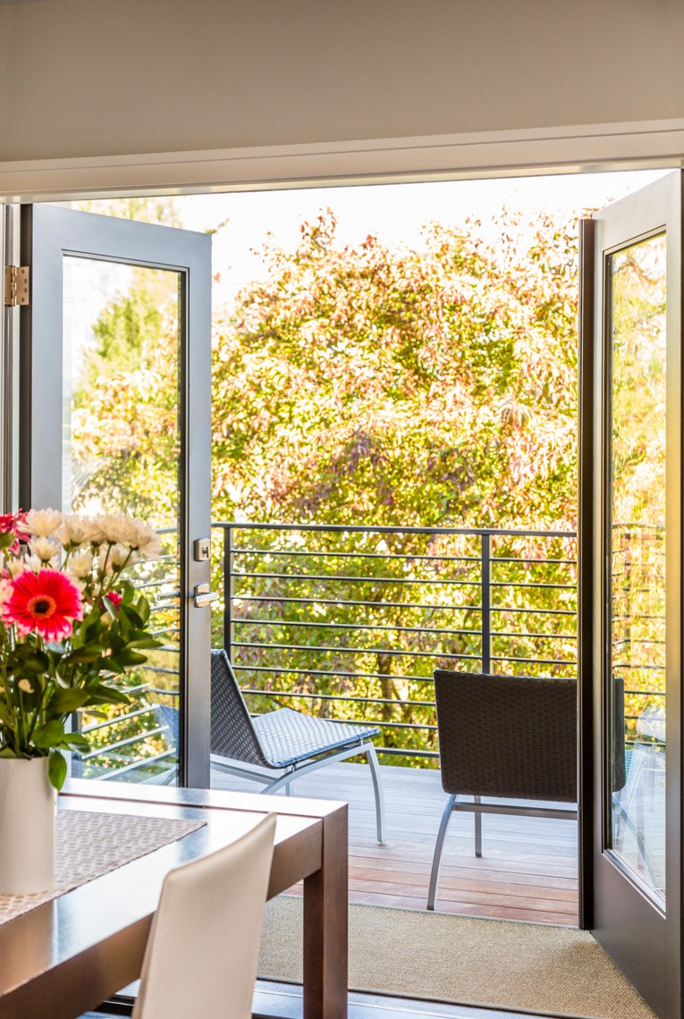 French doors windows opening to outdoor deck terrace in modern, contemporary, upscale home interior